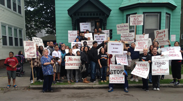 Photo of large crowd in front of house with protest signs